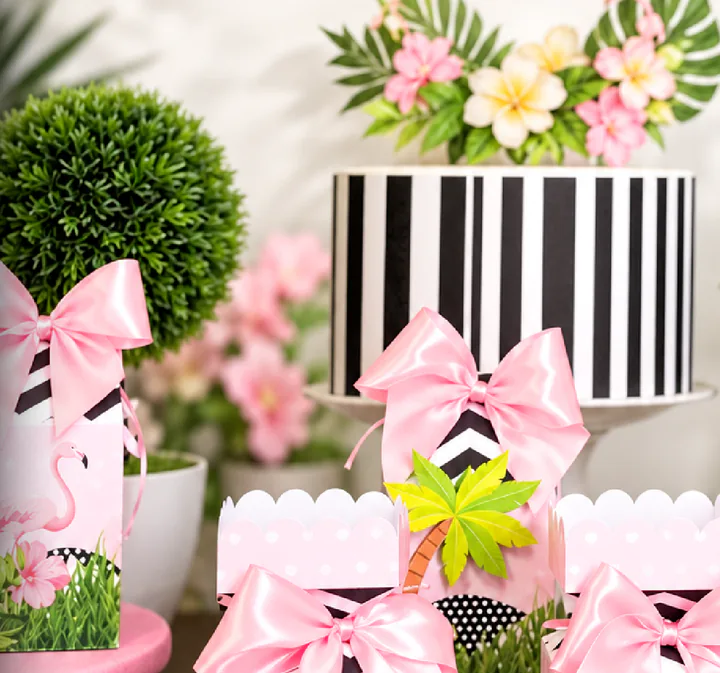 Cajas de regalo estampadas con lazos rosas y plantas decorativas.